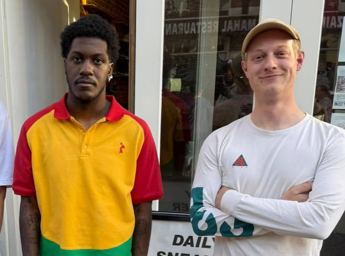 Lil Yachty in kleurrijke polo poseert met medewerker voor de winkel Daily Sneaker Steals in Rotterdam