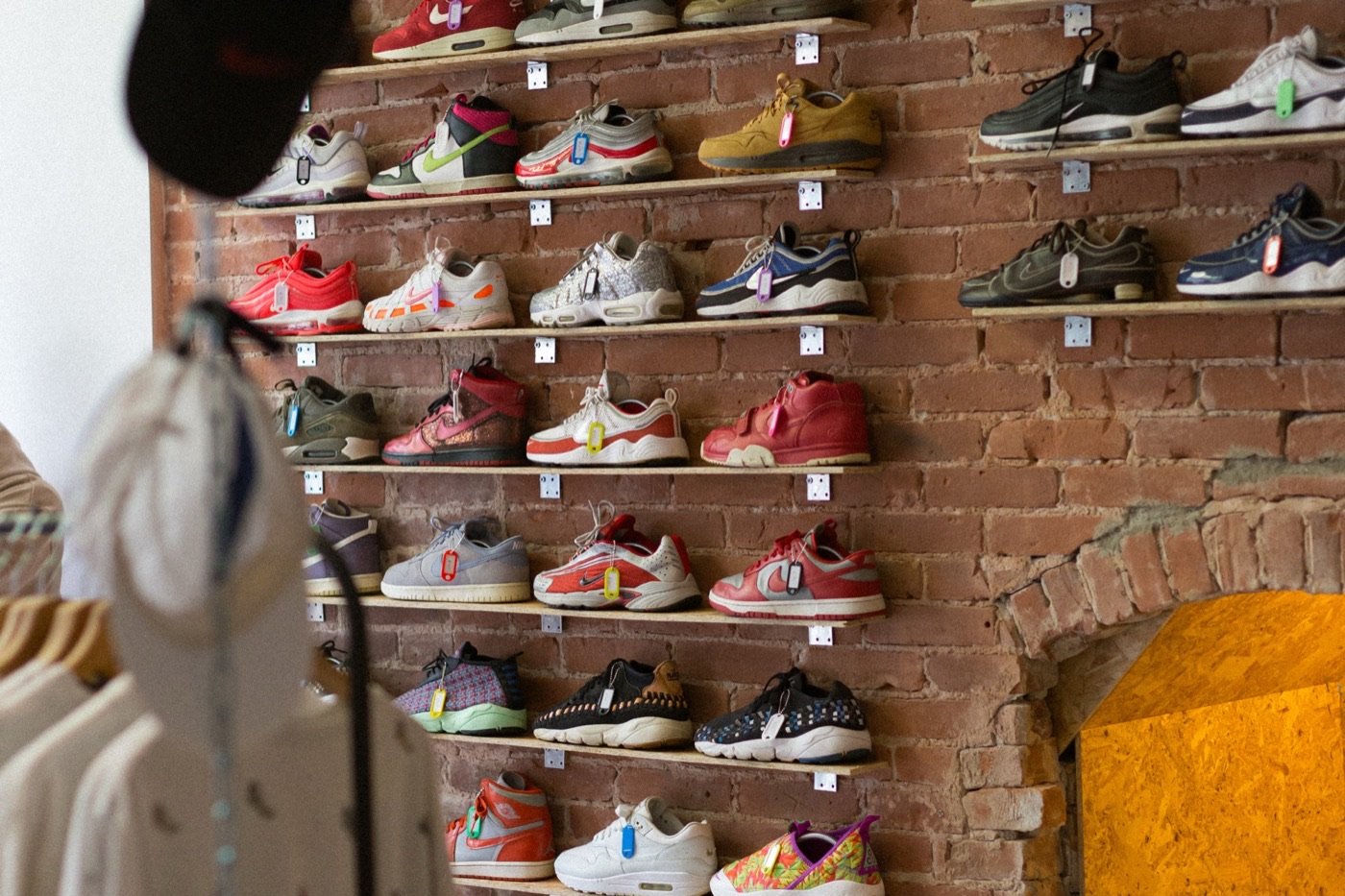 Schappen met sneakers tegen een bakstenen muur in de winkel